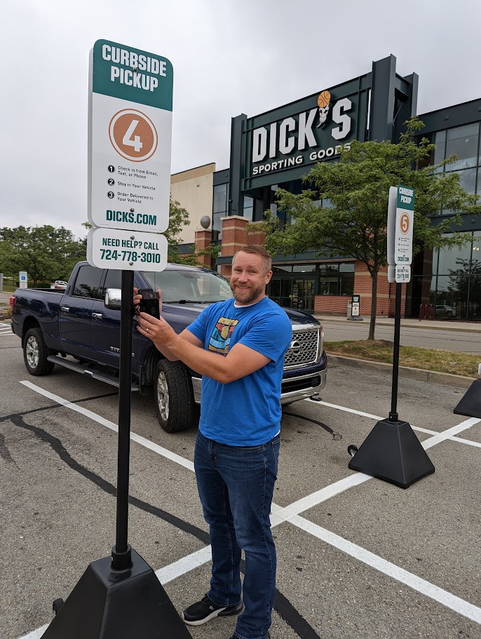Tim Wilson testing the curbside pickup camera rig on a sign in a store parking lot