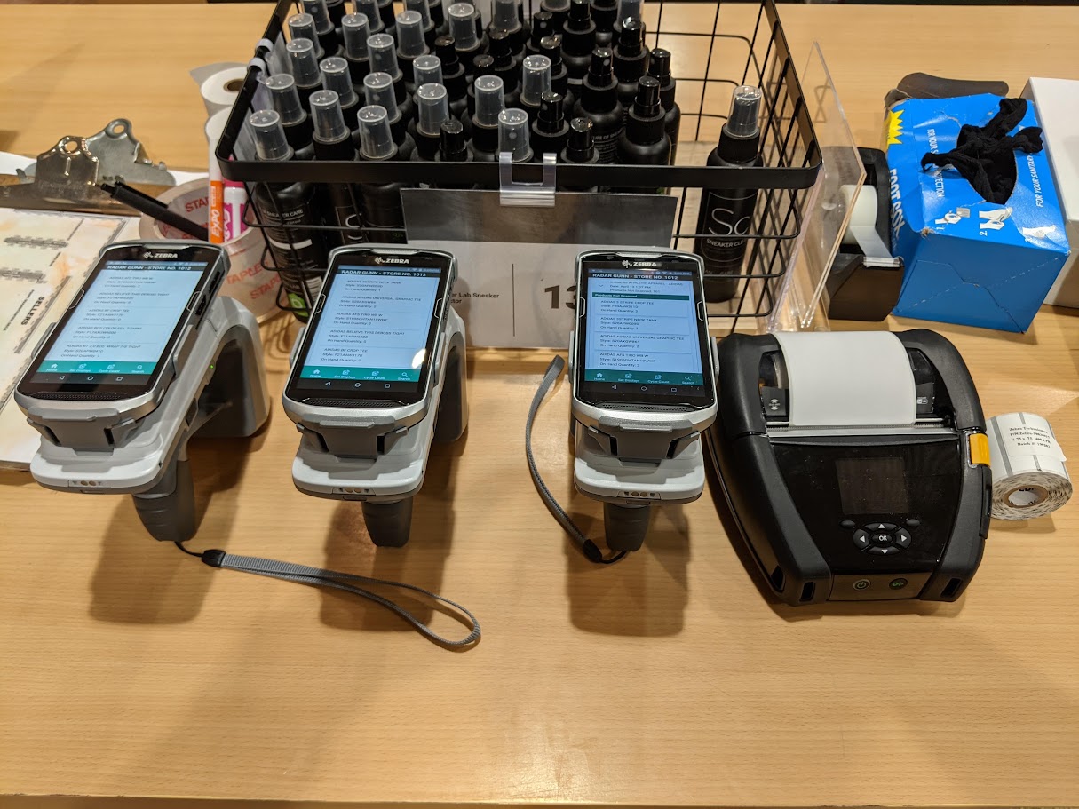 Three Zebra RFID handhelds running the cycle-counting app side by side in a store